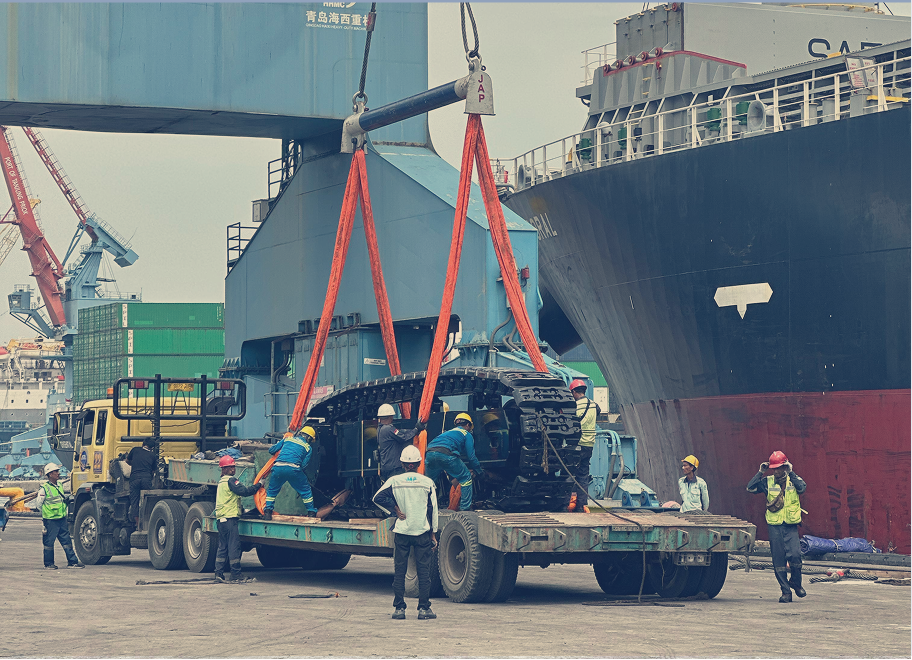 Efficient heavy equipment unloading operation showcasing teamwork and precision at the port